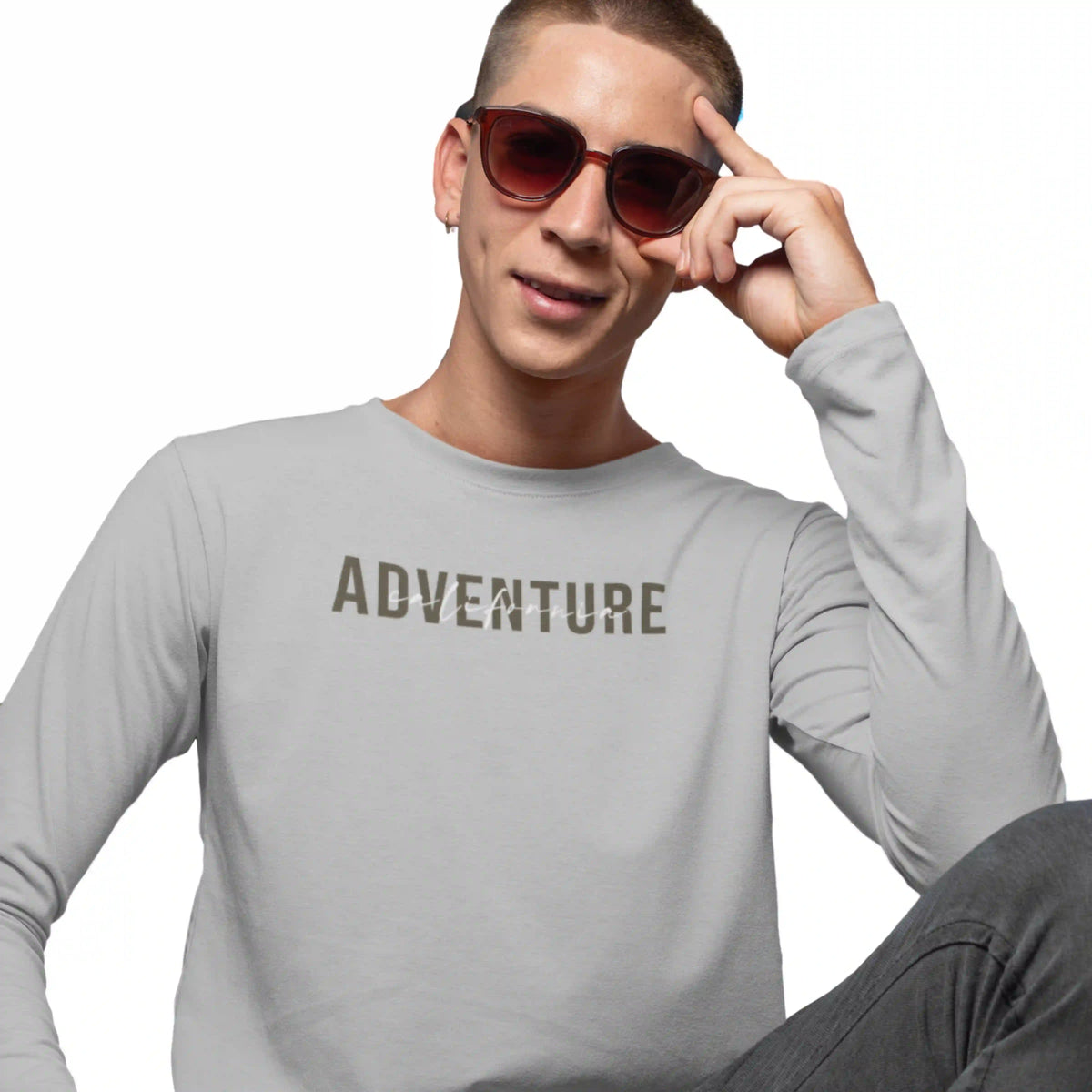 Person wearing a gray long-sleeve shirt with 'ADVENTURE' printed on it, sitting against a white background.