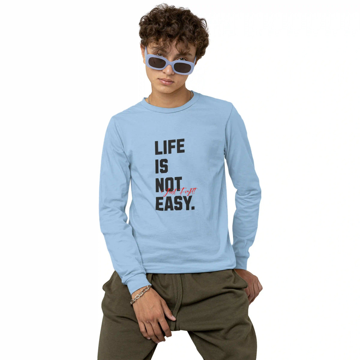 Child wearing a light blue long-sleeve shirt with 'Life is not easy' text, sitting against a white background.