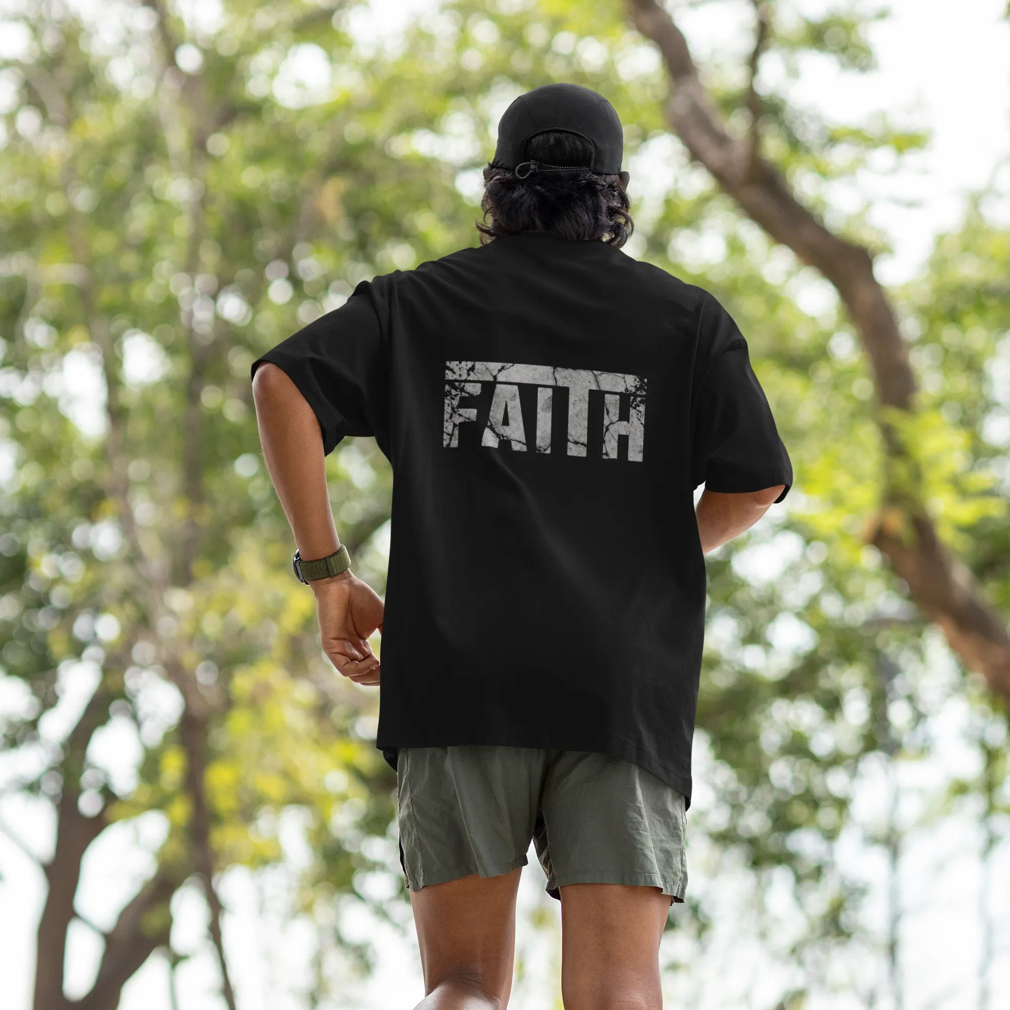 Person running outdoors wearing a black t-shirt with 'FAITH' printed on the back.