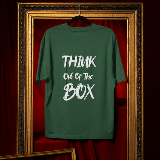 Green t-shirt with 'Think Out of the Box' text hanging in a decorative frame.