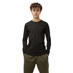 Person wearing a black long-sleeve shirt and green pants standing on a white platform with a plain background