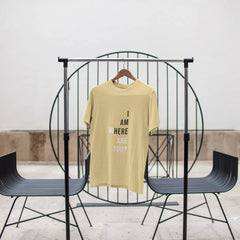 Yellow t-shirt with text on a black metal stand against a white wall.