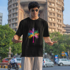 Person wearing a black t-shirt with a colorful design in an urban setting