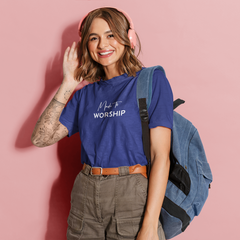 Woman wearing a blue t-shirt with text, holding a backpack against a pink background