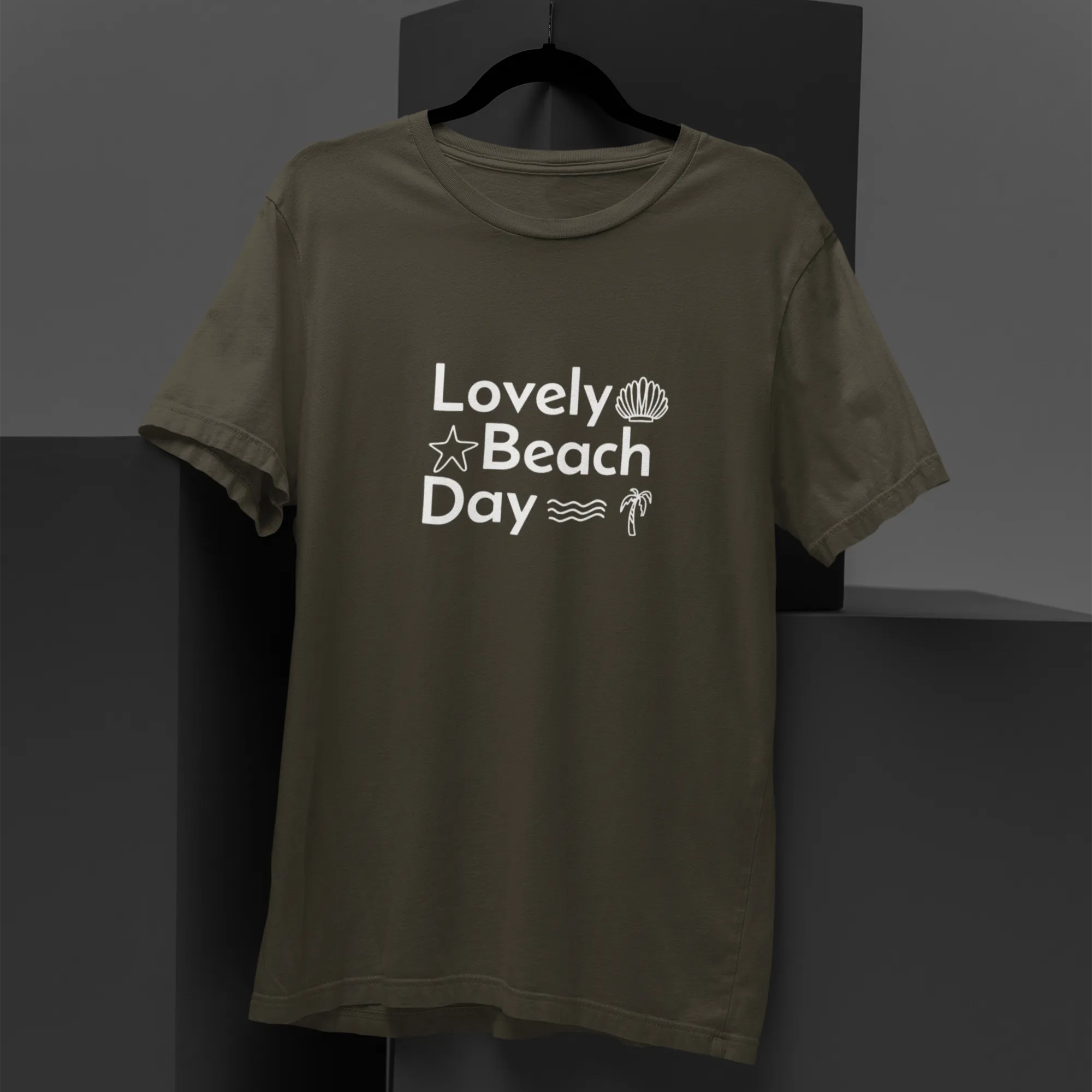 Green t-shirt with 'Lovely Beach Day' text on a black background