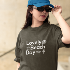 Person wearing a green t-shirt with 'Lovely Beach Day' text and graphics.