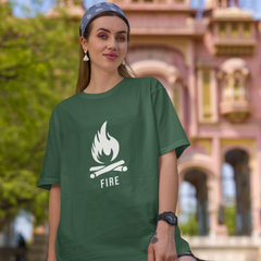 Person wearing a green t-shirt with 'FIRE' design in front of an architectural building.