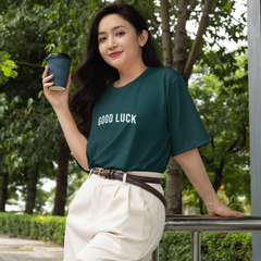 Woman holding a coffee cup outdoors with greenery in the background