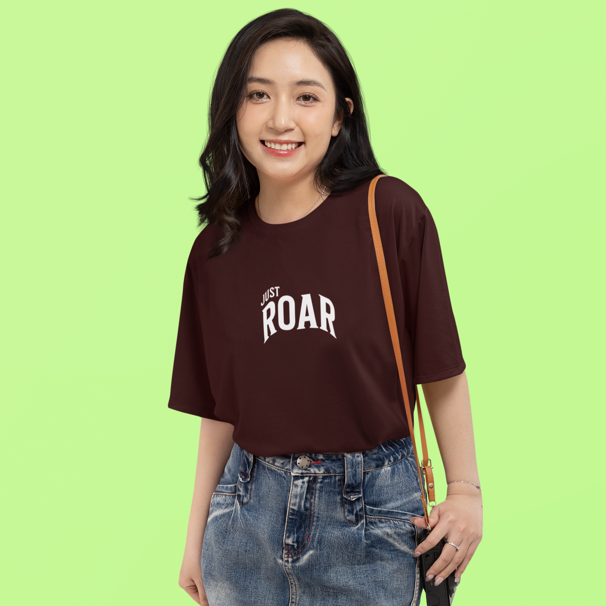 Woman wearing a brown t-shirt with 'JUST ROAR' text on a green background