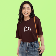 Woman wearing a brown t-shirt with 'JUST ROAR' text on a green background