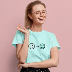 Woman wearing a light blue t-shirt with smiley face icons on a pink background