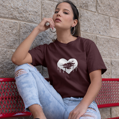 Woman sitting on a red bench wearing a brown t-shirt with a heart design.