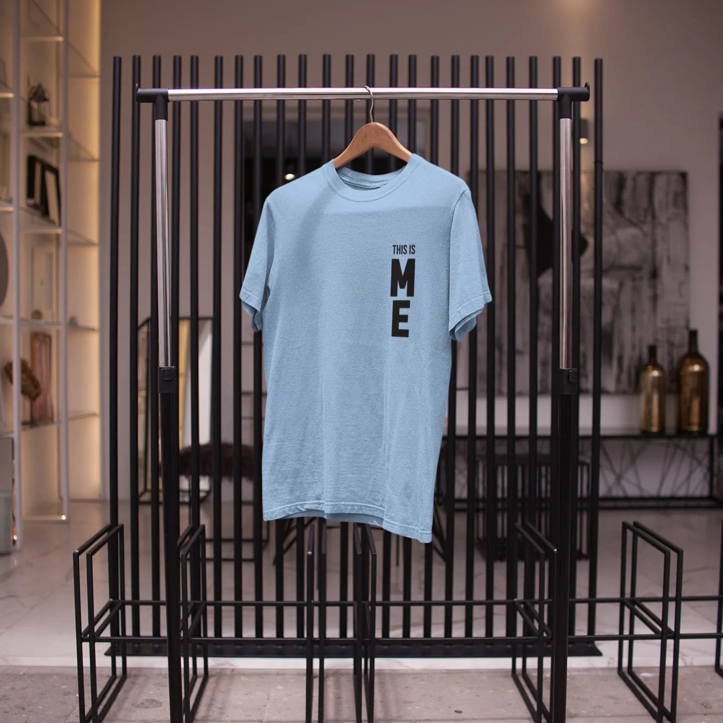 Light blue t-shirt with text on a black rack in a store setting