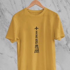 Yellow t-shirt with 'Follow Your Dream' text on a hanger against a marble background
