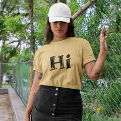 Woman wearing a yellow 'Hi' t-shirt and black skirt outdoors.