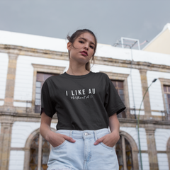 Woman wearing a black t-shirt with text, standing in front of a building.