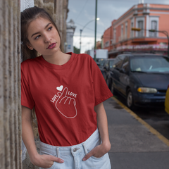 Woman wearing a red t-shirt with a graphic design on a city street.