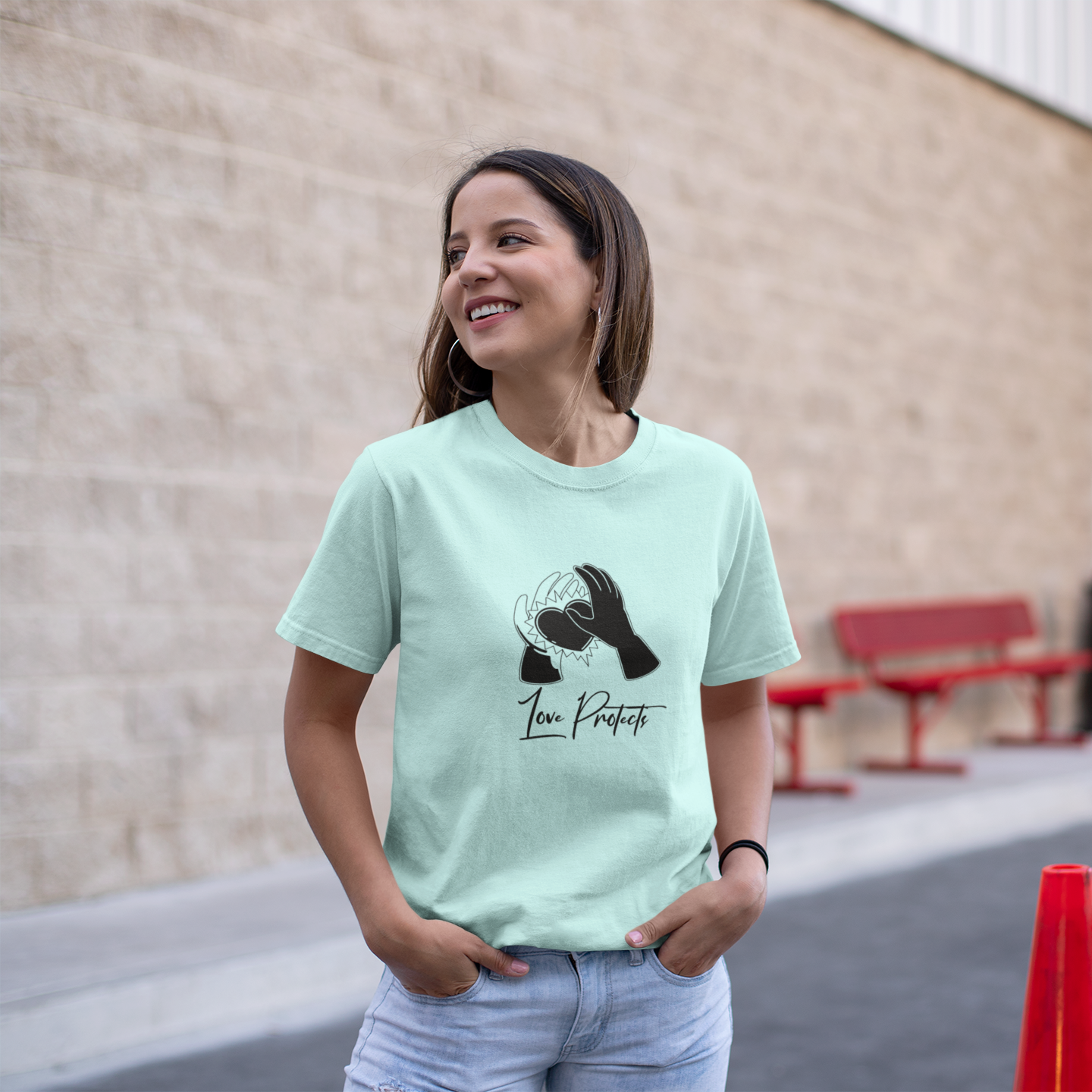 Woman wearing a light green t-shirt with a dog graphic and text, standing outdoors.