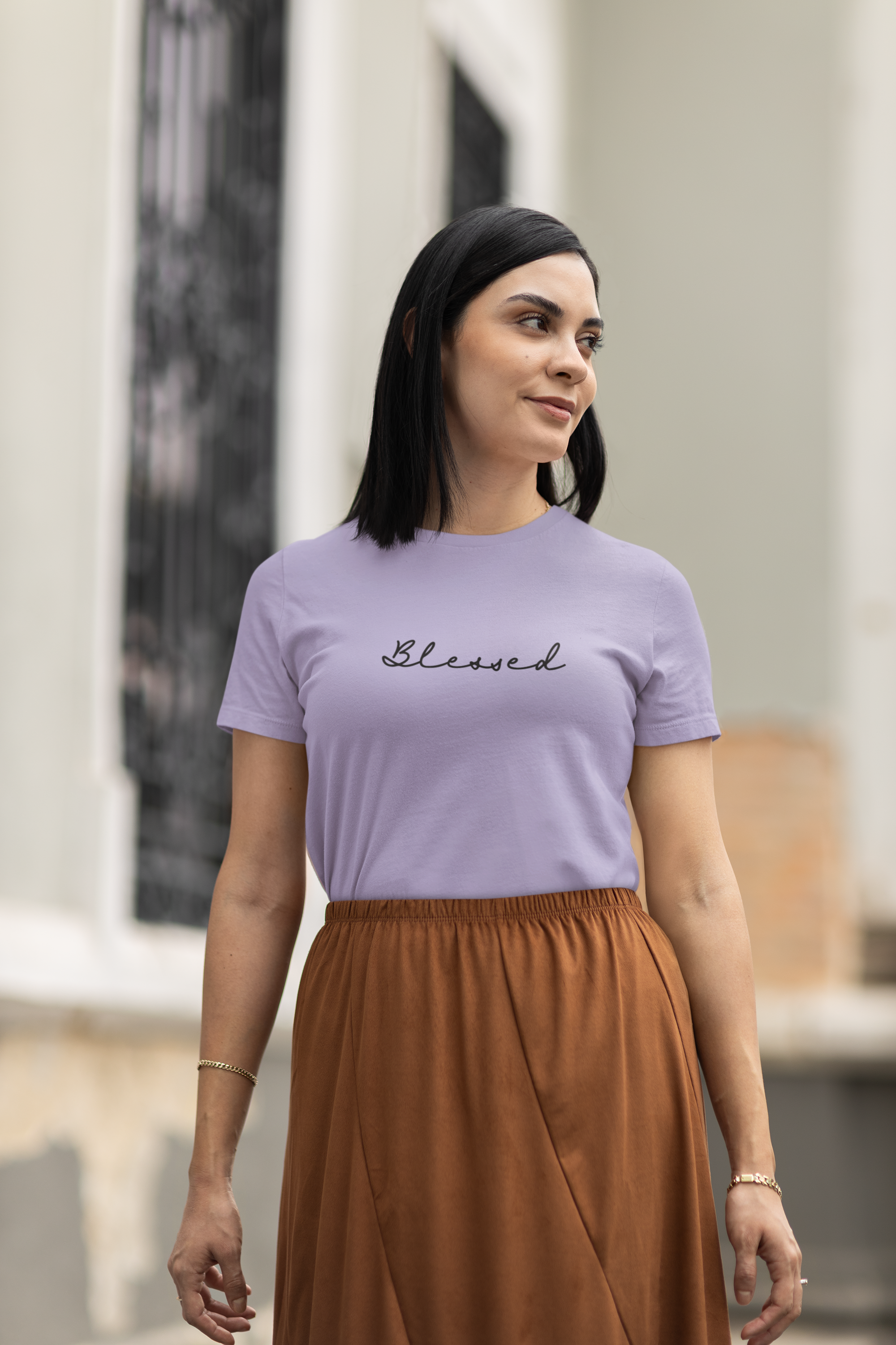 Woman wearing a purple t-shirt with 'Blessed' text, standing outdoors.
