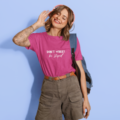 Woman wearing a pink t-shirt with text, standing against a light blue background