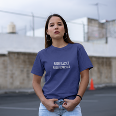 Woman wearing a blue t-shirt with text in an outdoor setting