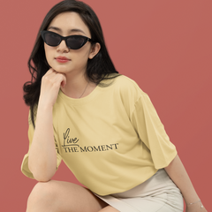 Woman wearing a yellow t-shirt with text and sunglasses against a red background