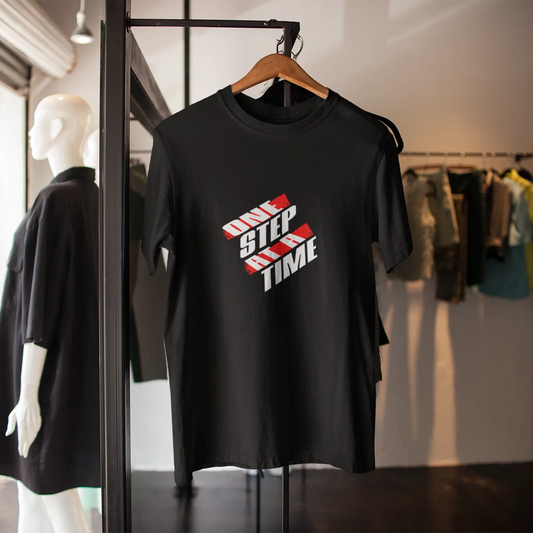 Black t-shirt with red and white text on a hanger in a clothing store.