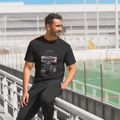 Man wearing a black t-shirt with graphics, standing on a sports field.