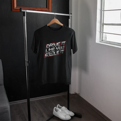 Black t-shirt with graphic design on a hanger in a room with a window.