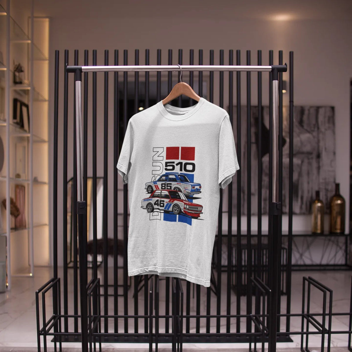 White t-shirt with graphic design on a black metal rack in a store setting