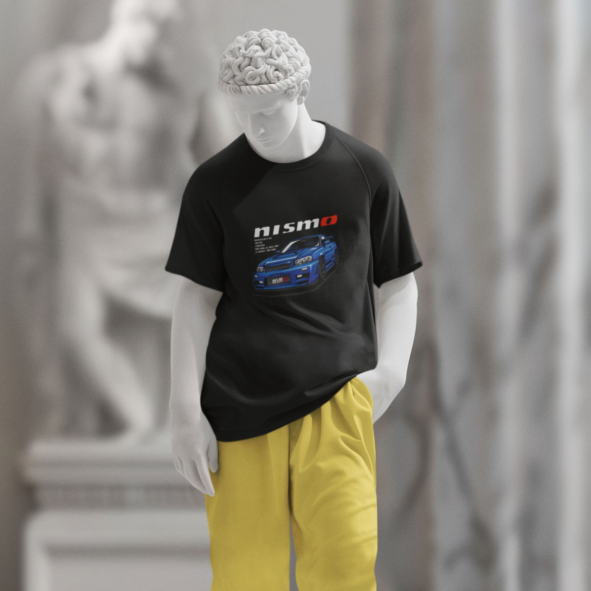 Mannequin wearing a black t-shirt with a graphic design and yellow pants in an indoor setting.