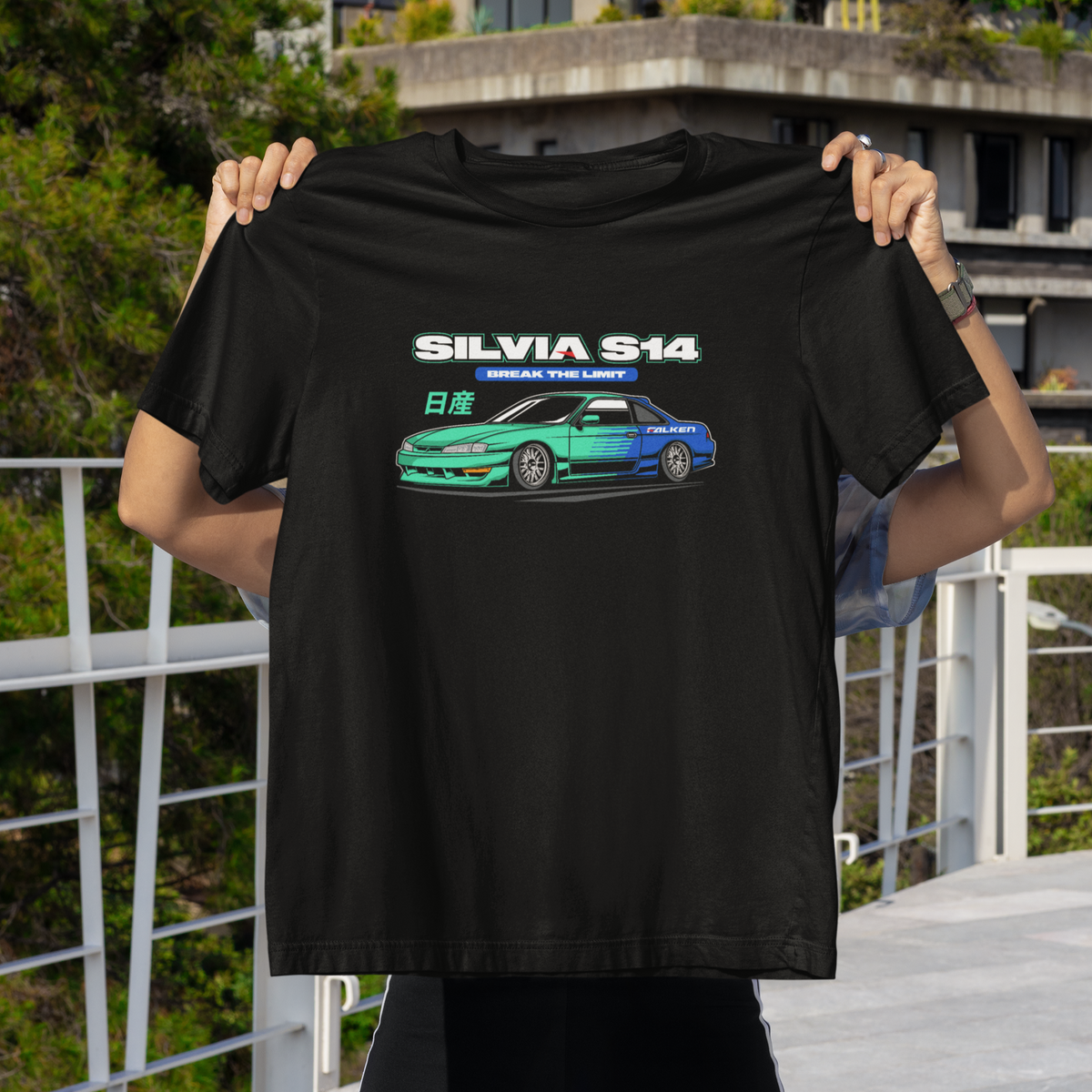 Person holding a black t-shirt with a car graphic and text in an outdoor setting.