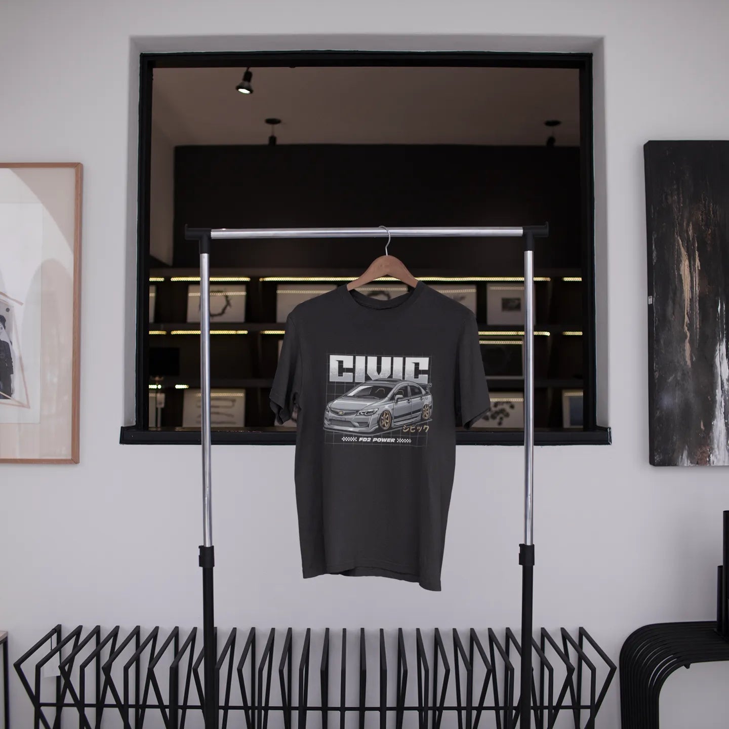Black t-shirt with 'Civic' design hanging on a rack in a modern interior setting.