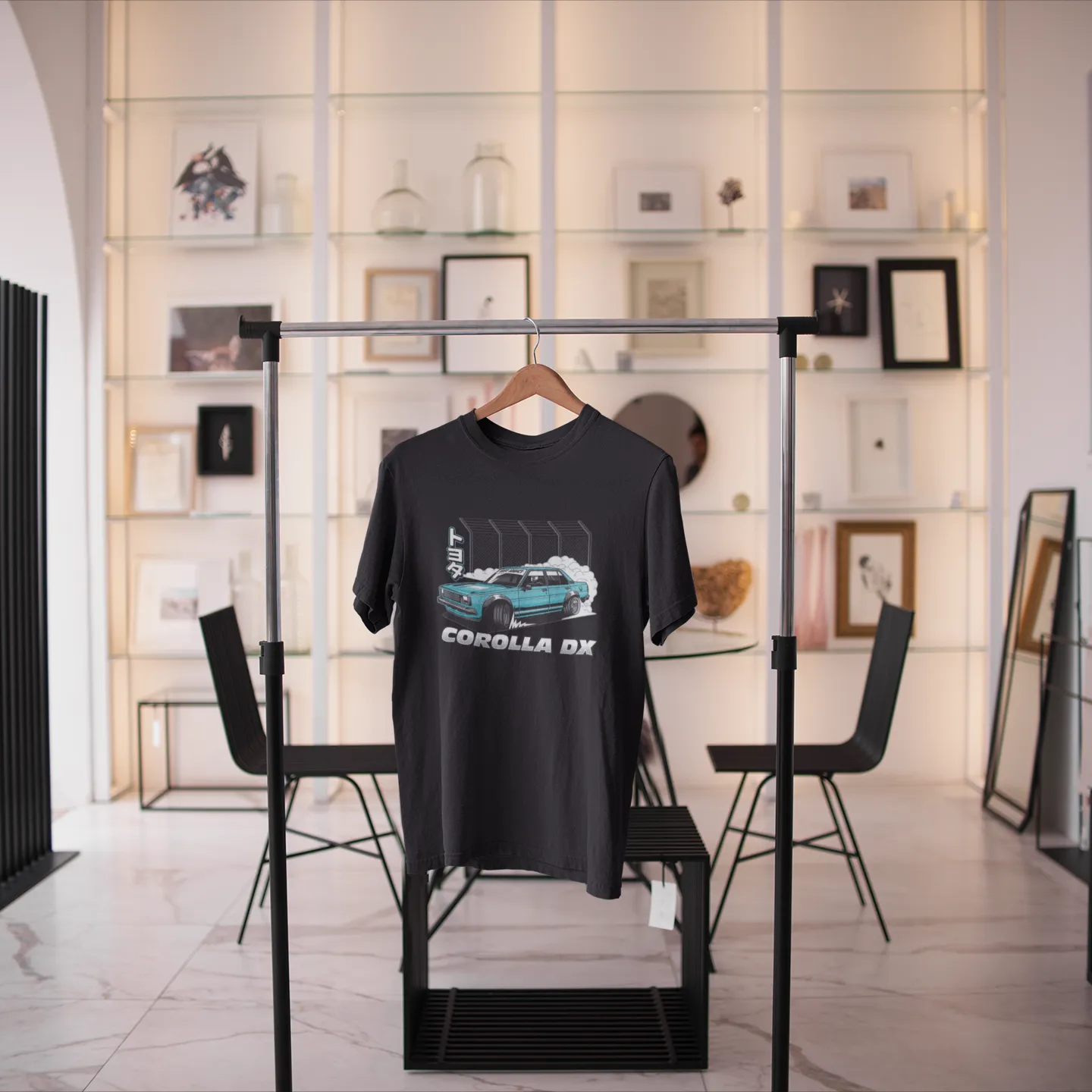 Black t-shirt with car graphic on a stand in a modern room with decor elements.
