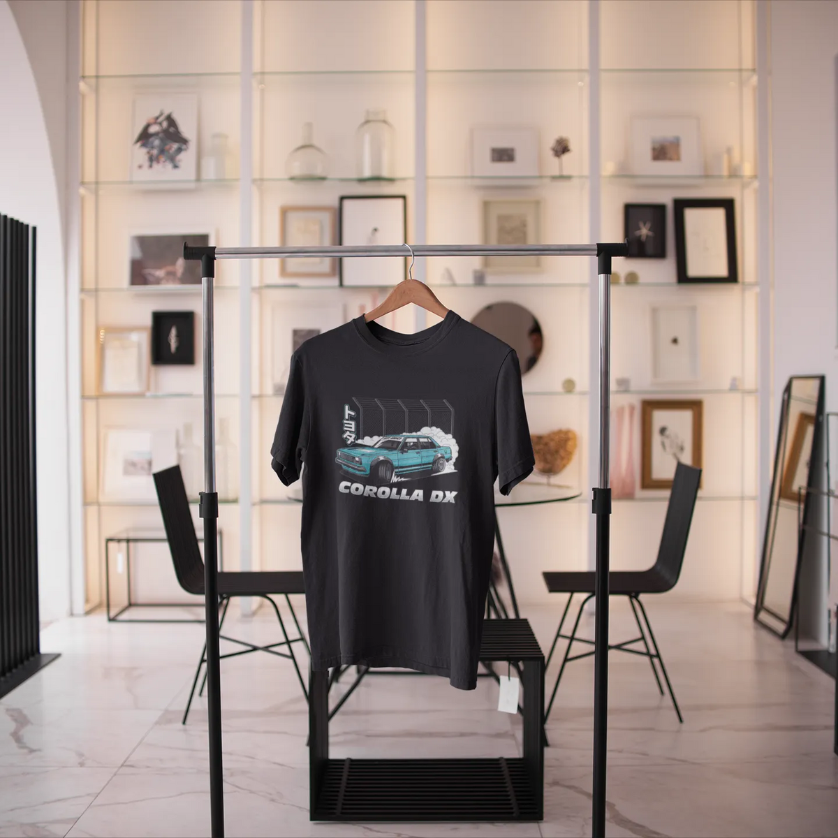 Black t-shirt with car graphic on a stand in a modern room with decor elements.