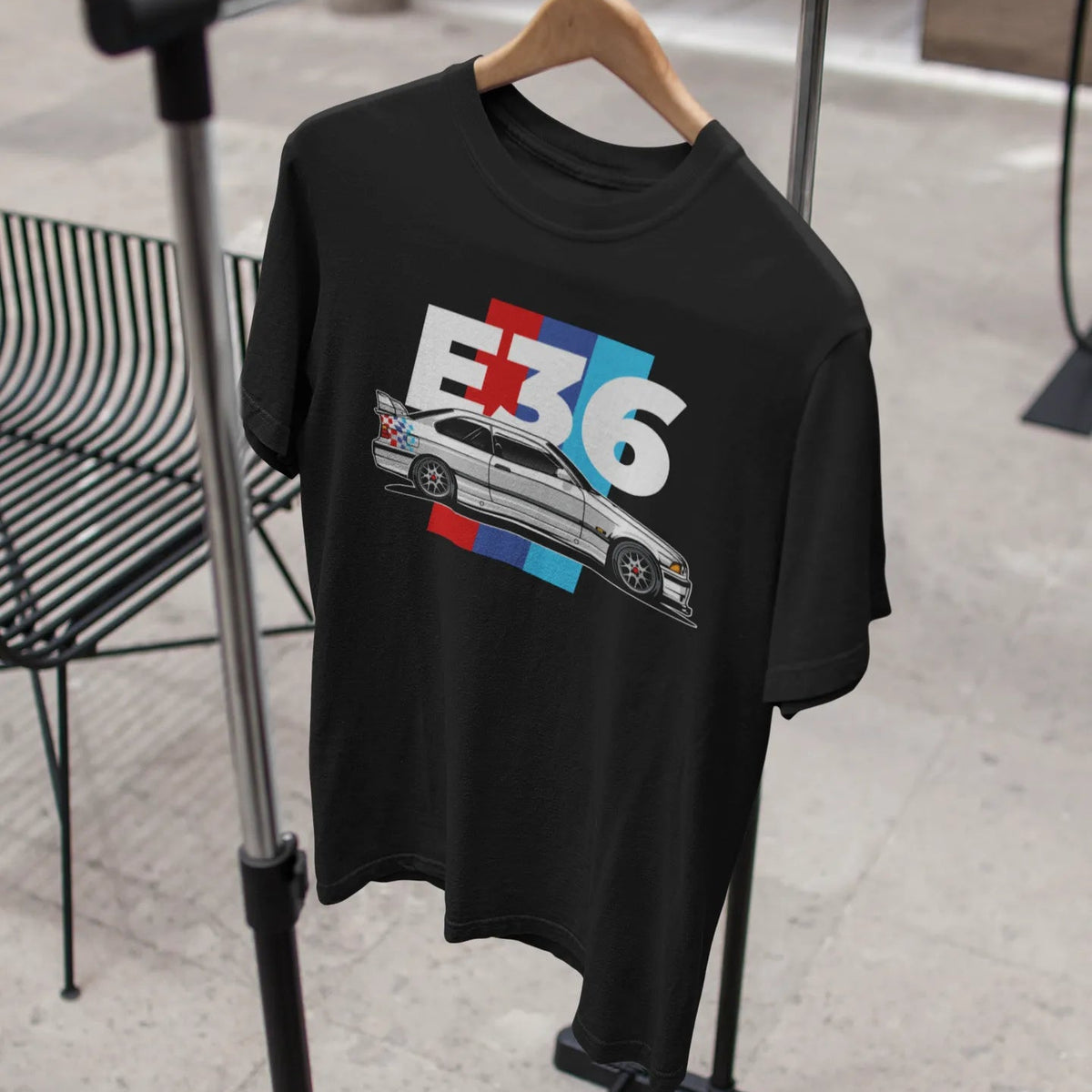 Black t-shirt with car graphic and 'E36' text on a hanger.