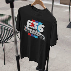 Black t-shirt with car graphic and 'E36' text on a hanger.