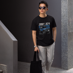 Man wearing a black t-shirt with 'Jimmy 1974' graphic, holding a black bag, standing against a gray wall.
