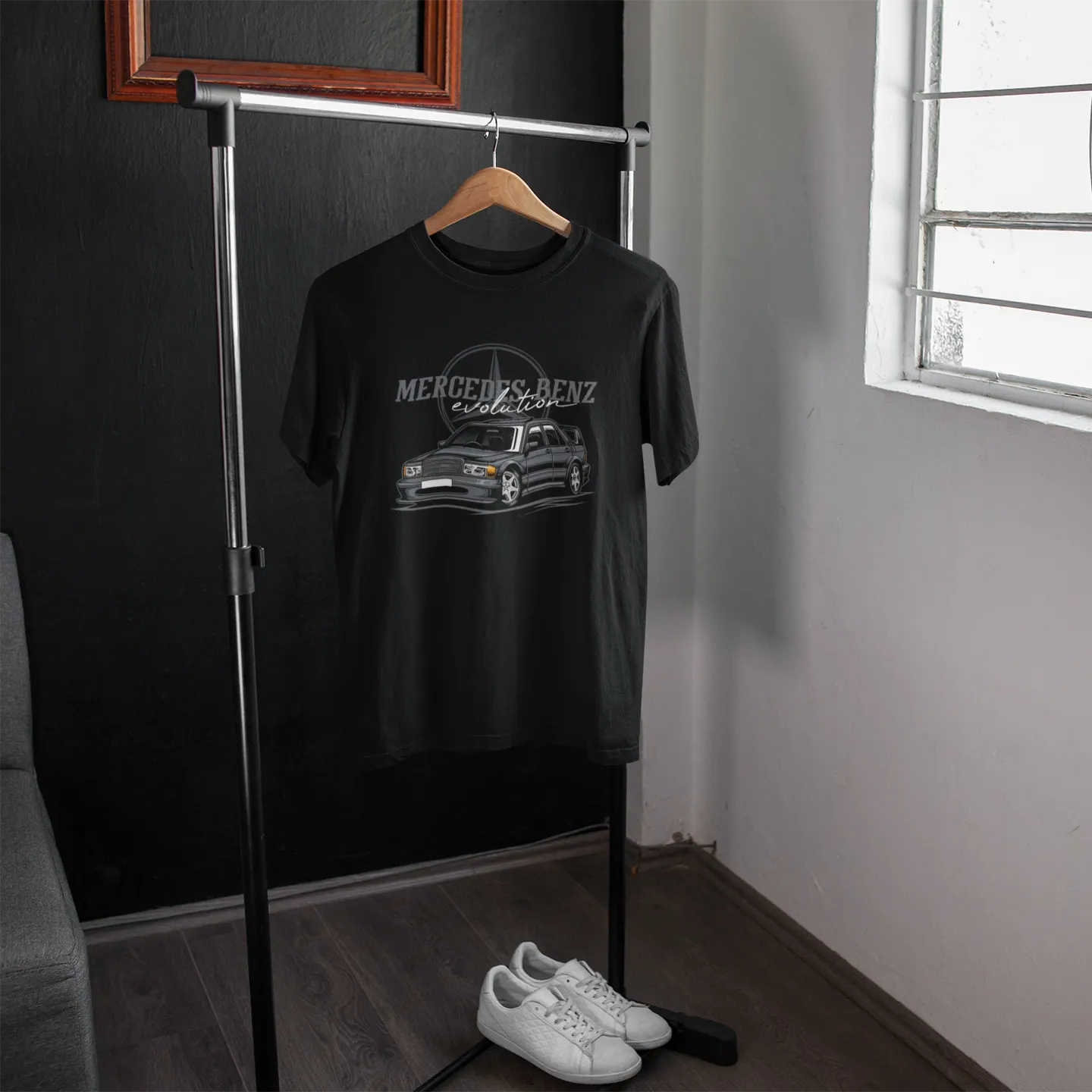 Black t-shirt with Mercedes-Benz logo on a hanger in a room with a window.