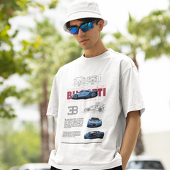Man wearing a white t-shirt with car graphics and text, standing outdoors with trees and vehicles in the background.