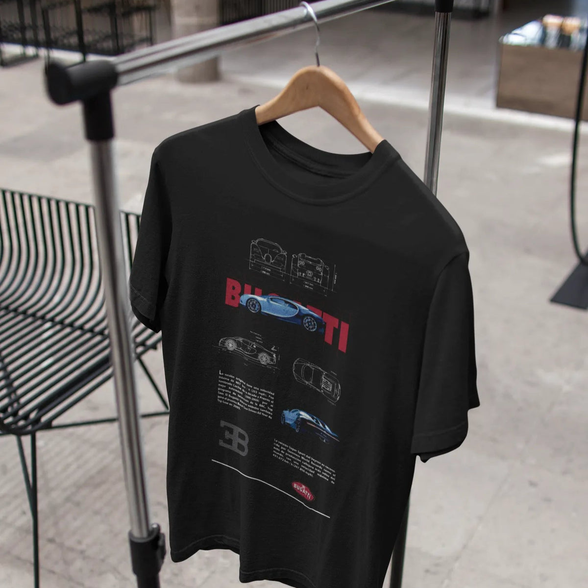 Black t-shirt with graphic design on a hanger against a blurred indoor background