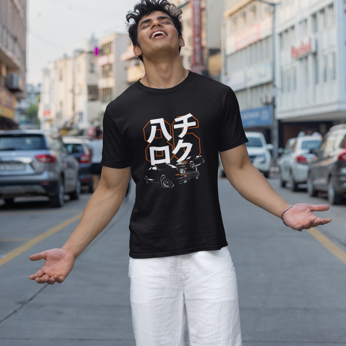 Person wearing a black t-shirt with white text on a city street