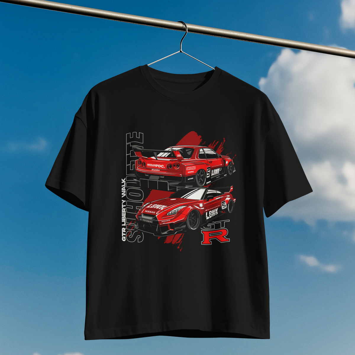 Black t-shirt with red car graphics on a hanger against a blue sky.