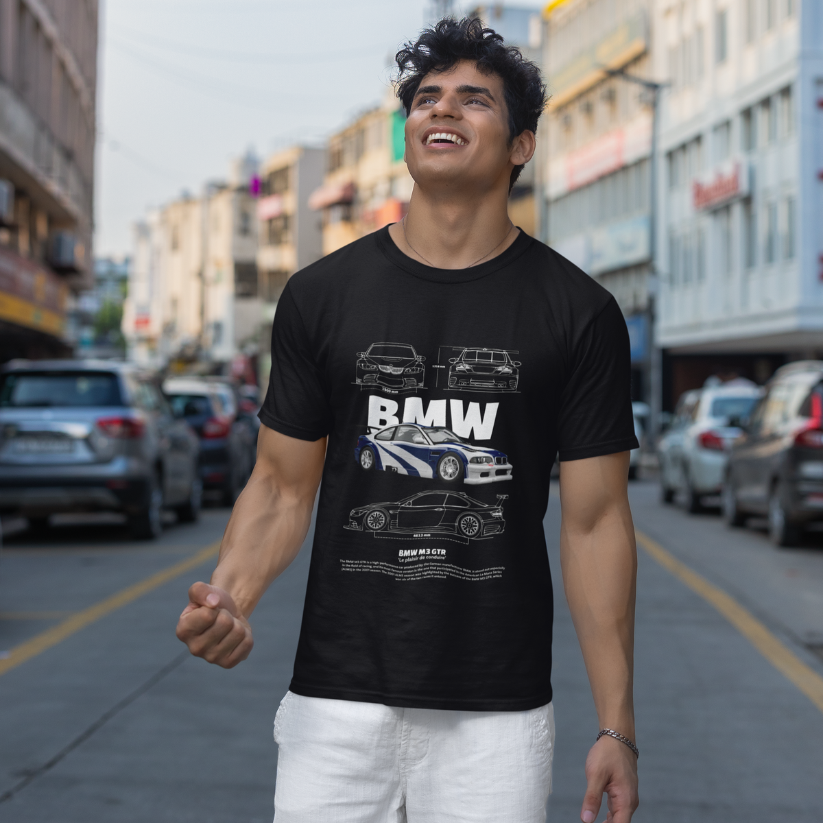 Man wearing a black t-shirt with BMW logo on a city street