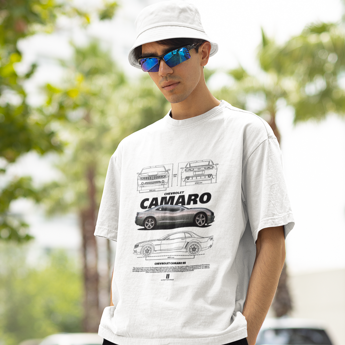 Man wearing a white t-shirt with a car graphic and 'Camaro' text, standing outdoors.