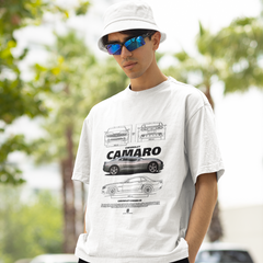 Man wearing a white t-shirt with a car graphic and 'Camaro' text, standing outdoors.