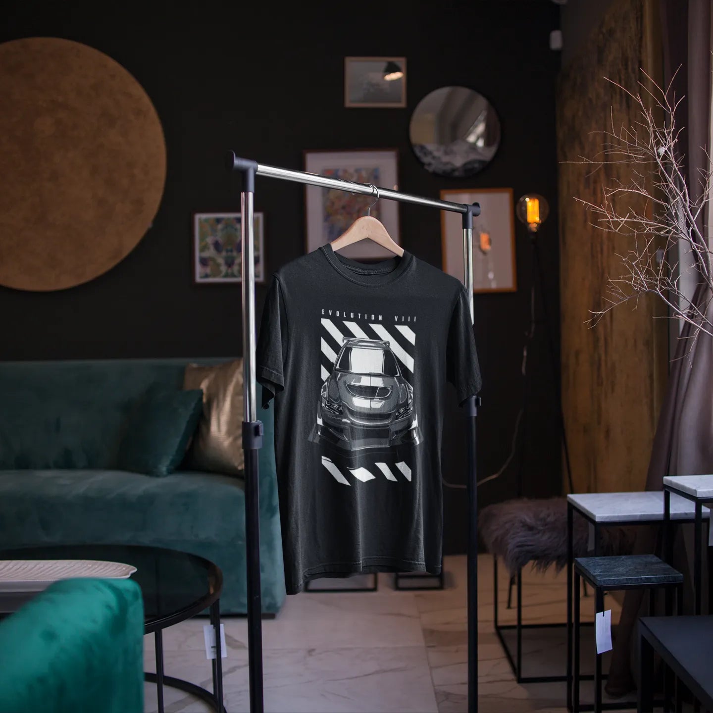 Black t-shirt with a graphic design on a stand in a stylish room with green sofa and decor.