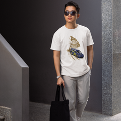 Man wearing a white t-shirt with a graphic design, holding a black bag, and standing in an indoor setting.
