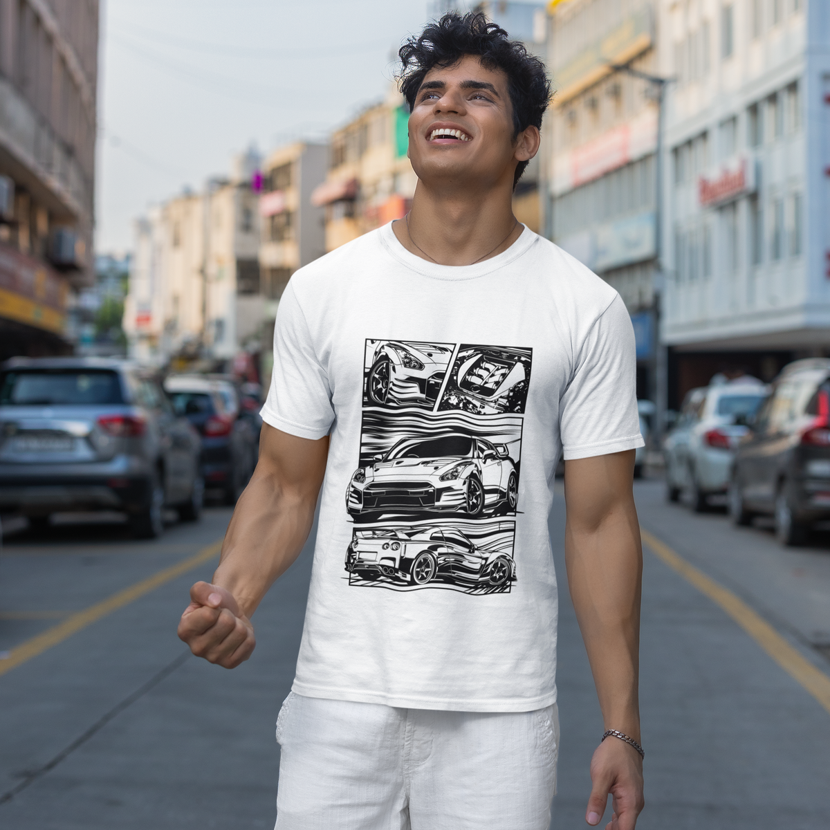 Man wearing a white t-shirt with graphic designs on a city street