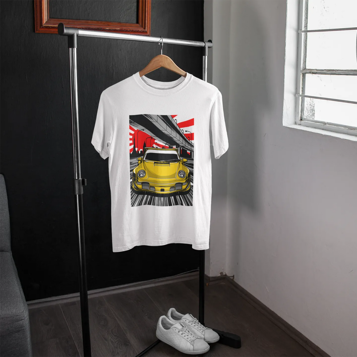 White t-shirt with a graphic design of a yellow car on a hanger in a room.